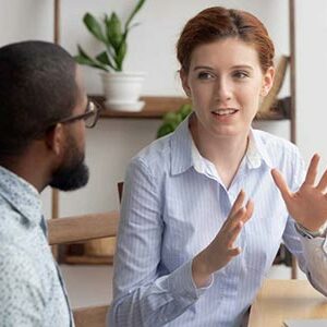 Deux collègues en discussion animée lors du débriefing d’un rapport DISC, EIQ ou Clifton Strengths, dans le cadre d’un échange visant à mieux comprendre leurs forces et leurs comportements.