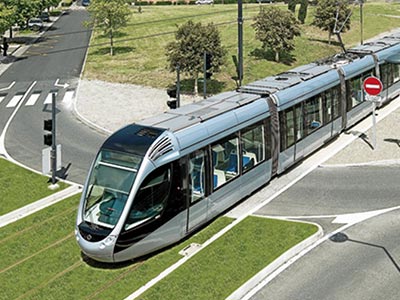 Un tramway moderne circulant sur des voies vertes, illustrant l’engagement de Leaderseed pour une mobilité responsable et écologique.