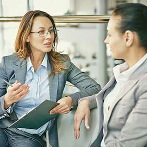 Deux femmes en discussion lors d’une session de supervision pour coachs, symbolisant l’expertise et le soutien offerts par Leaderseed.